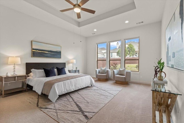 carpeted bedroom featuring recessed lighting, a raised ceiling, visible vents, and baseboards