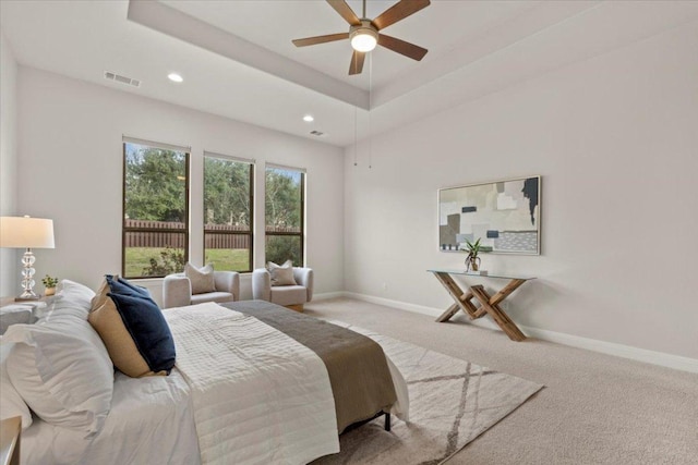 bedroom featuring carpet floors, baseboards, visible vents, and a raised ceiling