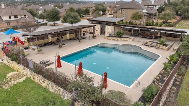 pool featuring a residential view, fence, outdoor dry bar, and a patio