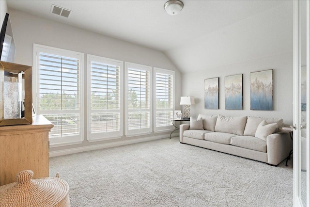 living area with vaulted ceiling, carpet flooring, and visible vents