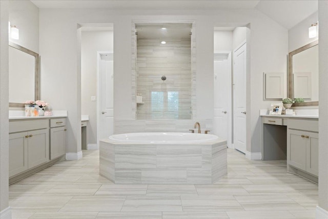 full bath with tiled shower, vanity, a bath, and baseboards