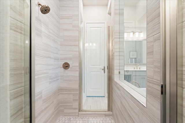 bathroom with tiled shower and vanity