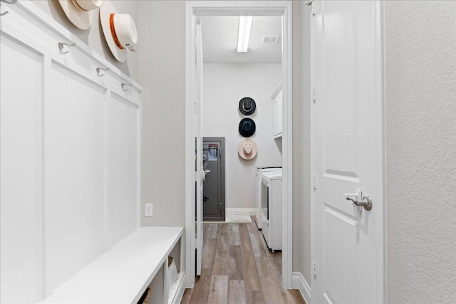 mudroom featuring wood finished floors and separate washer and dryer