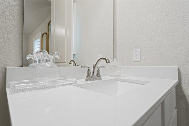 bathroom featuring vanity and a textured wall