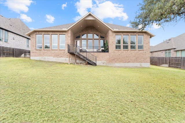 back of property featuring a yard, a fenced backyard, and brick siding