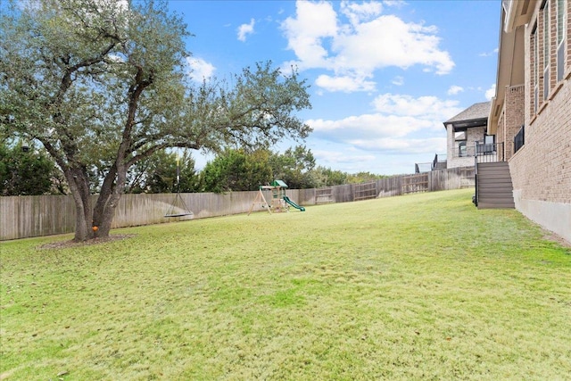 view of yard featuring a fenced backyard and a playground