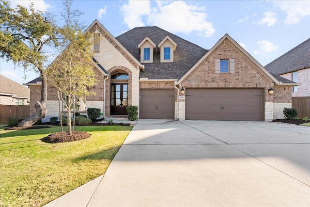 french provincial home featuring a front yard, stone siding, brick siding, and fence