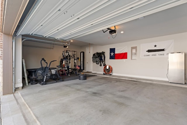 garage featuring freestanding refrigerator and a garage door opener