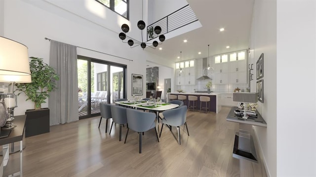 dining area with light wood-style floors, recessed lighting, and a towering ceiling