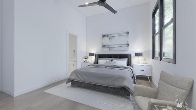 bedroom with a ceiling fan, ensuite bath, baseboards, and wood finished floors