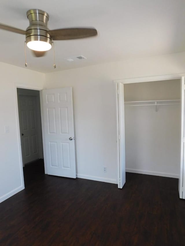 unfurnished bedroom with visible vents, baseboards, a ceiling fan, dark wood finished floors, and a closet