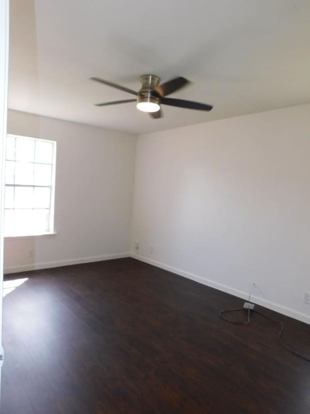 unfurnished room featuring dark wood-style floors, baseboards, and a ceiling fan