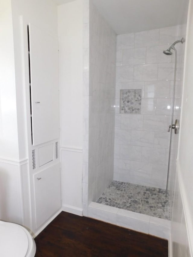 bathroom featuring a stall shower, wood finished floors, and toilet