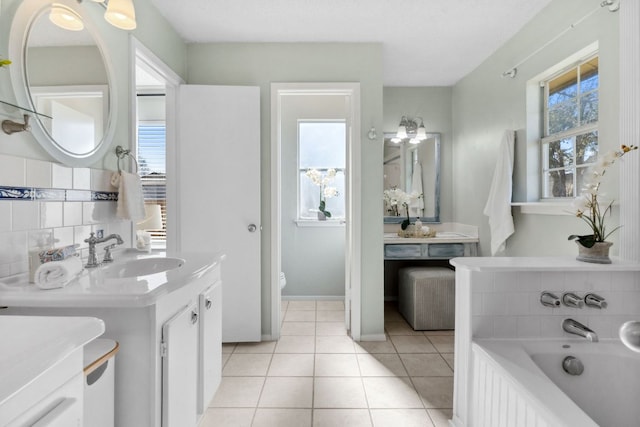 full bath with a garden tub, two vanities, toilet, a sink, and tile patterned floors