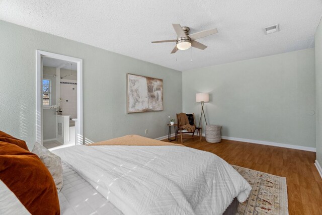 bedroom with visible vents, baseboards, a ceiling fan, wood finished floors, and a textured ceiling