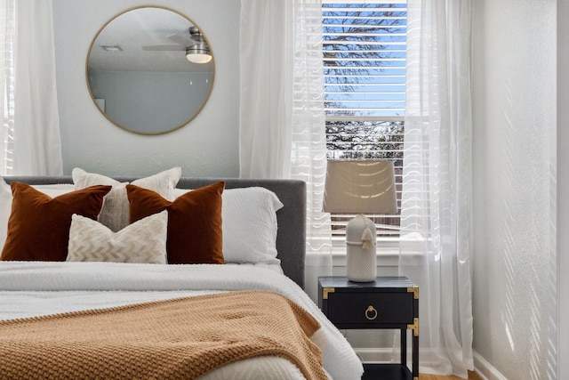 bedroom featuring baseboards and a textured wall