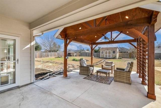 view of patio / terrace featuring a fenced backyard, a storage unit, and an outdoor structure