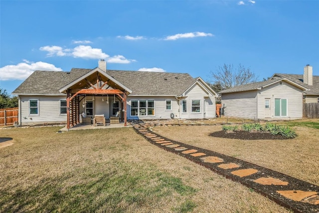 back of house with a patio area, a chimney, fence, and a lawn