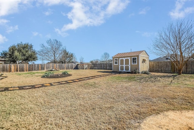 view of yard with a fenced backyard, a storage unit, and an outbuilding