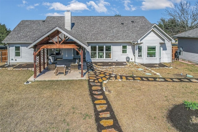 rear view of house featuring a yard, a patio, a chimney, and fence