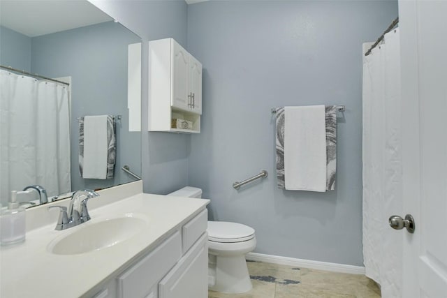 bathroom featuring toilet, vanity, and baseboards