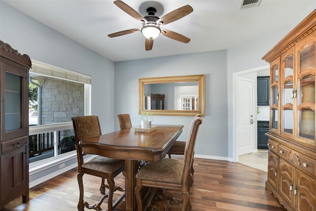 dining space with visible vents, ceiling fan, baseboards, and wood finished floors