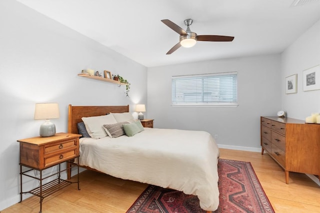 bedroom featuring light wood finished floors, baseboards, and a ceiling fan