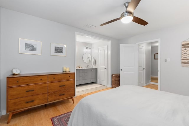 bedroom featuring connected bathroom, visible vents, baseboards, a ceiling fan, and light wood-type flooring