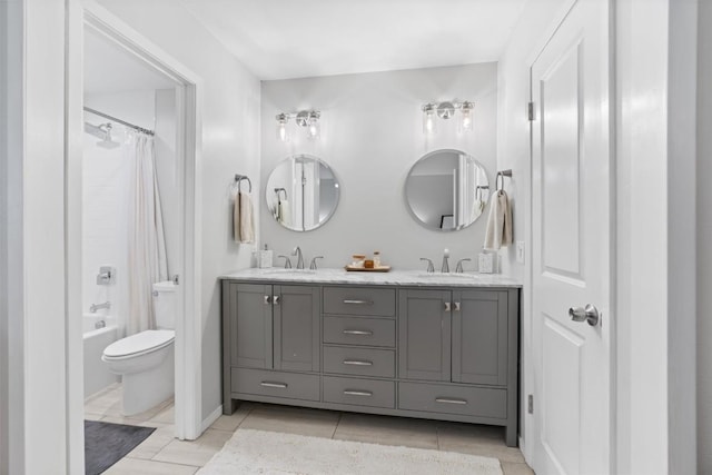 bathroom featuring tile patterned floors, a sink, toilet, and double vanity