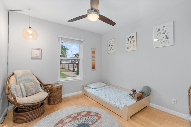 bedroom with ceiling fan, baseboards, and wood finished floors