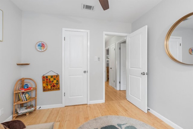 interior space with visible vents, ceiling fan, light wood-style flooring, and baseboards