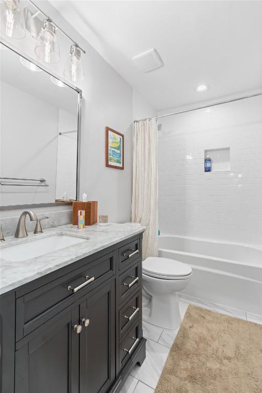 full bath featuring visible vents, shower / tub combo, vanity, and toilet