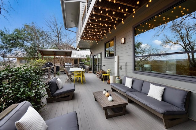 wooden terrace featuring outdoor dining area, a grill, and outdoor lounge area