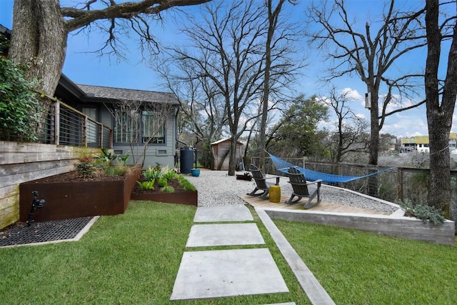 view of yard featuring an outdoor structure, a patio, and fence