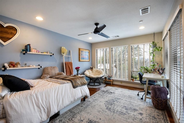 bedroom featuring a ceiling fan, visible vents, wood finished floors, and recessed lighting