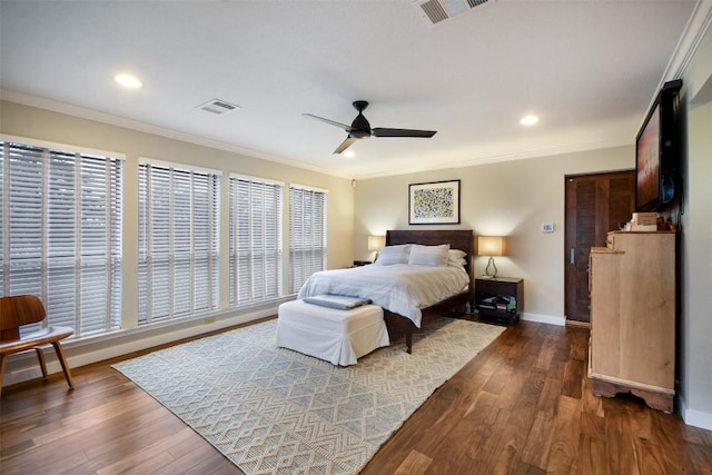 bedroom featuring dark wood-style floors, baseboards, visible vents, and crown molding