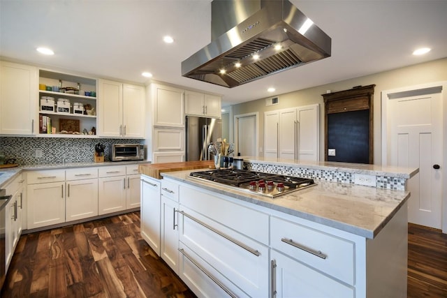 kitchen with a center island, dark wood-style flooring, stainless steel appliances, white cabinetry, and wall chimney exhaust hood