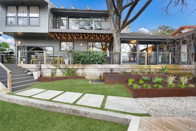 back of property featuring a lawn and a balcony