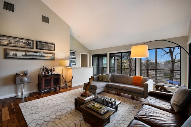 living room with high vaulted ceiling, wood finished floors, visible vents, and baseboards