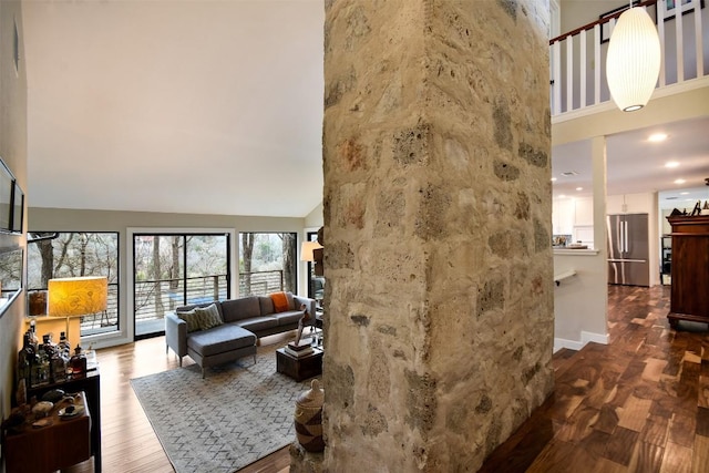 living area featuring a towering ceiling and wood finished floors