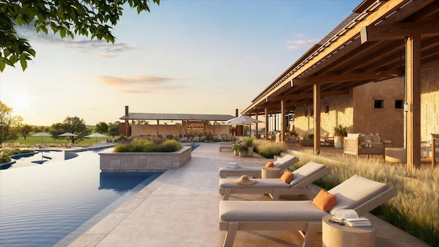 patio terrace at dusk featuring an outdoor pool