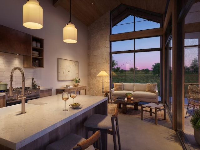 kitchen with decorative backsplash, a kitchen breakfast bar, light countertops, high vaulted ceiling, and pendant lighting