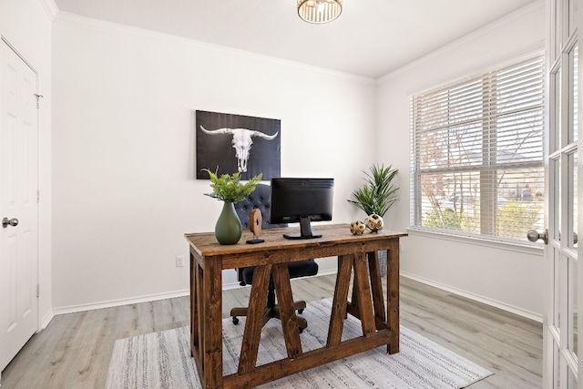 office area with baseboards, crown molding, and light wood finished floors