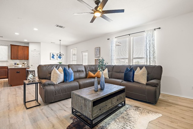 living area featuring a healthy amount of sunlight, visible vents, and light wood-style flooring