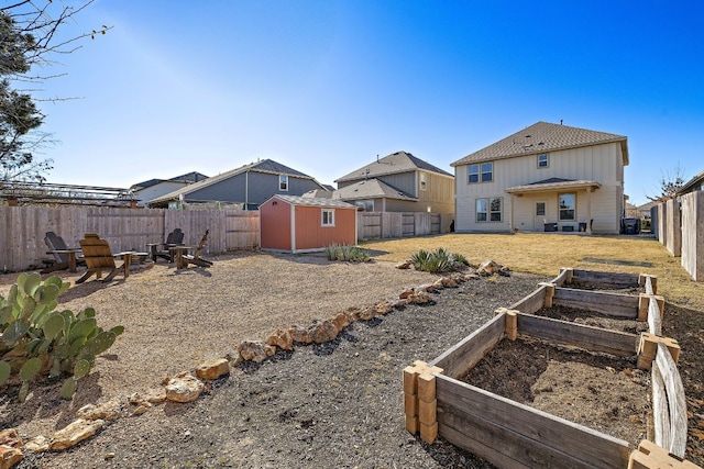 view of yard with an outbuilding, a fenced backyard, a vegetable garden, and a storage shed