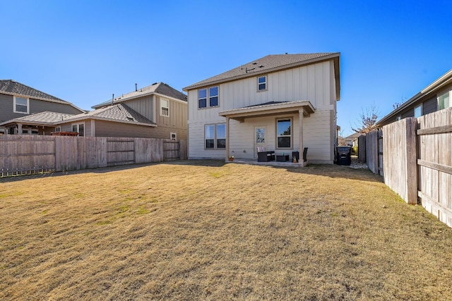 back of property featuring a fenced backyard, a patio, board and batten siding, and a yard