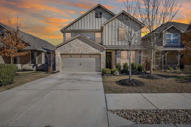 view of front of home with a garage, stone siding, board and batten siding, and concrete driveway