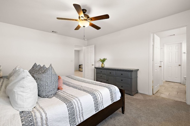 bedroom featuring a ceiling fan, visible vents, and light colored carpet