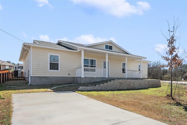 view of front facade with covered porch, fence, and a front lawn