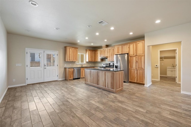 kitchen with visible vents, appliances with stainless steel finishes, a center island, light wood-style floors, and recessed lighting